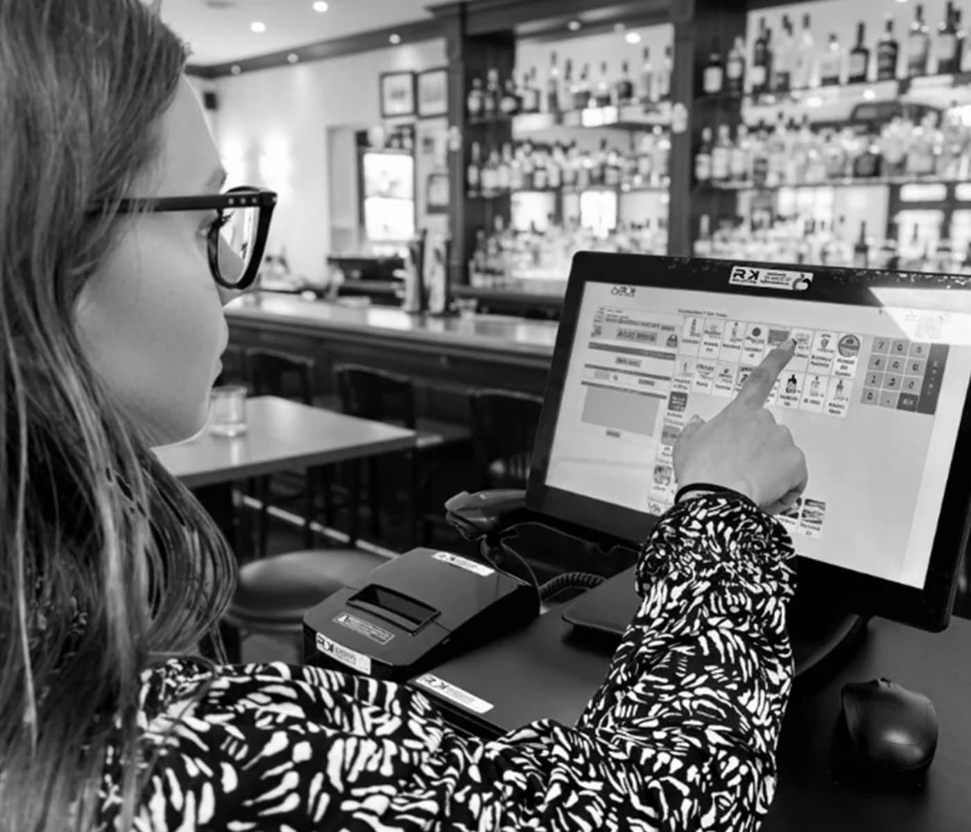 Mujer usando la pantalla de venta de RK en la barra de un bar